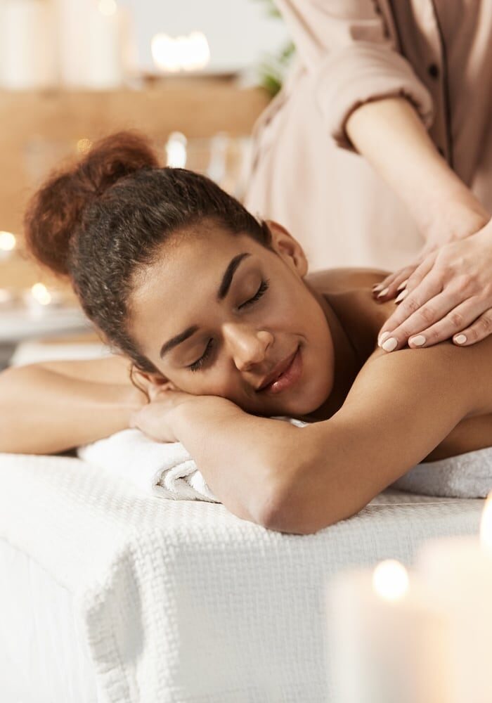 woman-smiling-enjoying-massage-with-closed-eyes-spa-salon